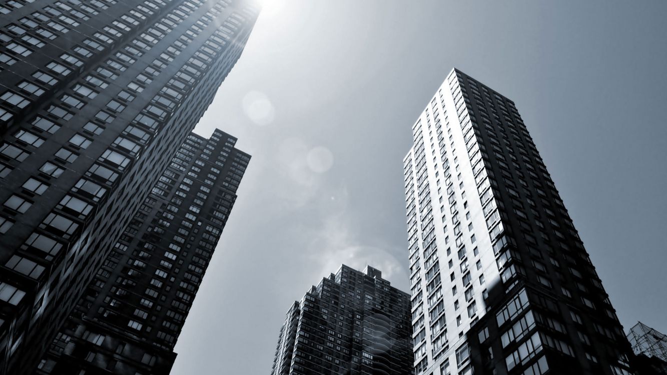 low angle photography of high rise buildings under white clouds during daytime