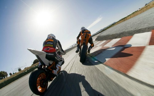 Image man in orange and white jacket riding on white and orange motocross dirt bike