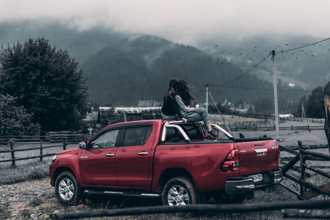 Wallpaper Woman in Black Jacket Sitting on Red Car Hood During Daytime,  Background - Download Free Image
