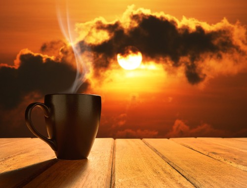 Image white ceramic mug on brown wooden table during sunset