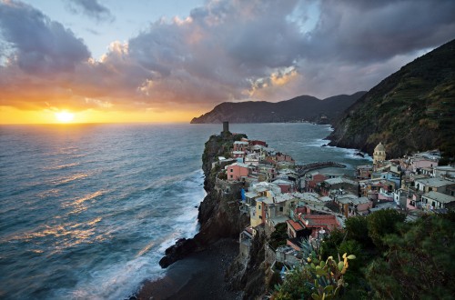 Image houses on cliff near sea during sunset