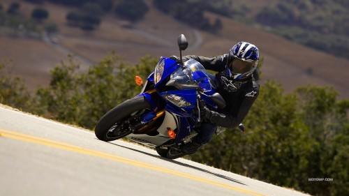 Image man in black and blue motorcycle suit riding on black sports bike on road during daytime