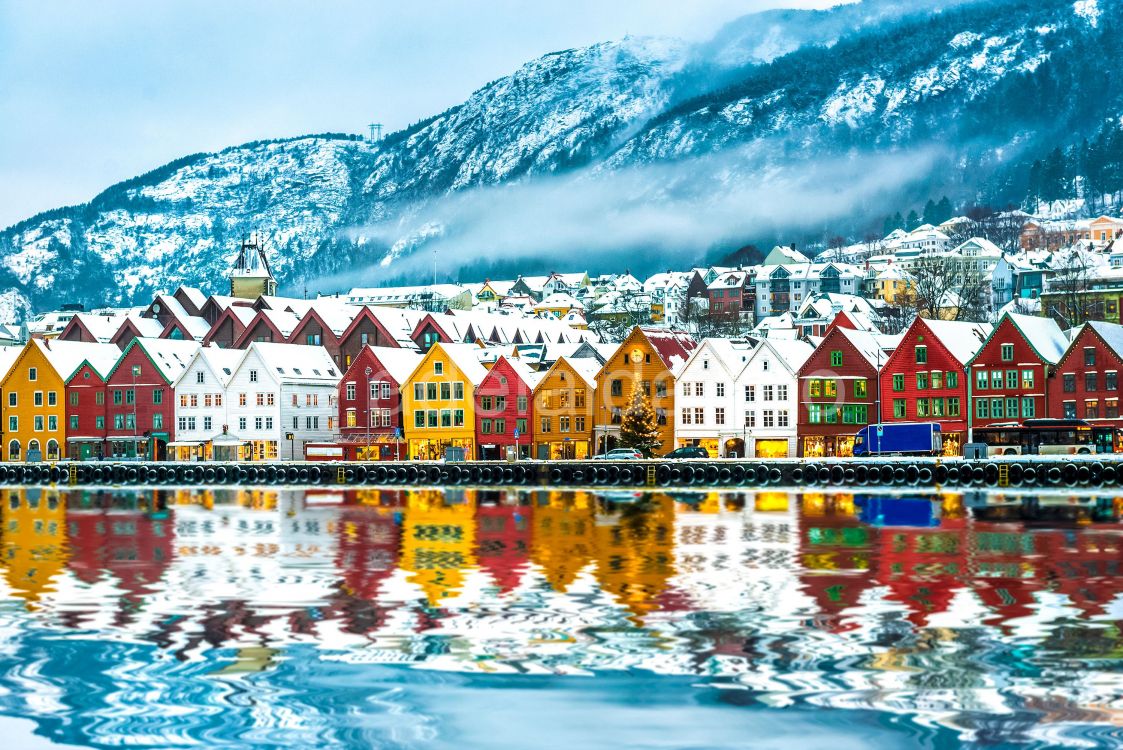 houses near body of water and mountain