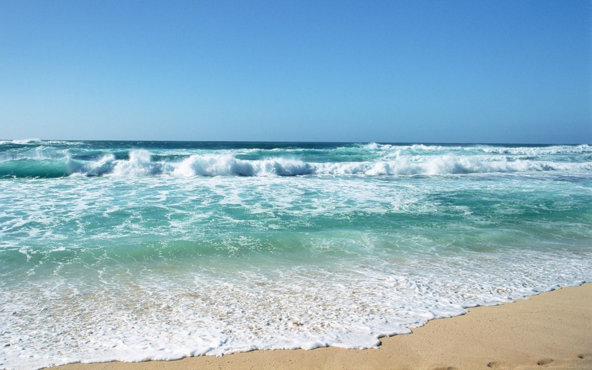 sea waves crashing on shore during daytime