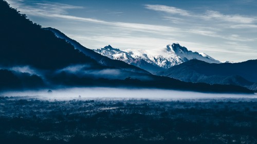 Image snow covered mountains under cloudy sky during daytime