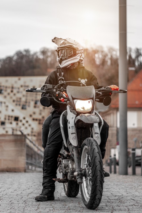 Image man in black leather jacket riding motorcycle during daytime