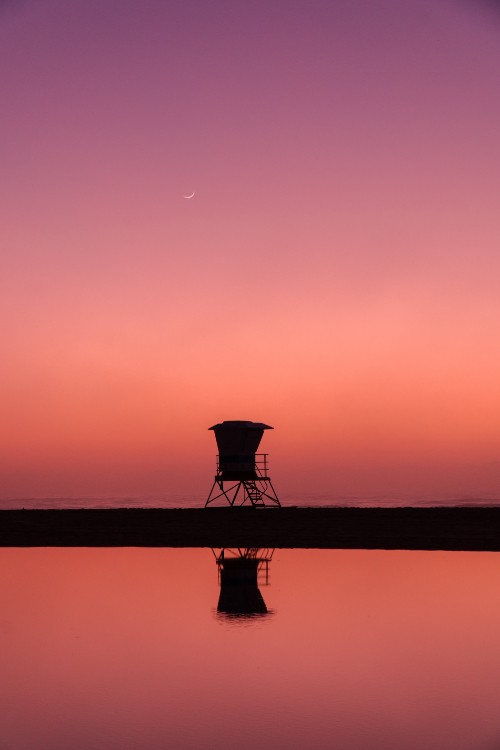 Image silhouette of person standing on dock during sunset