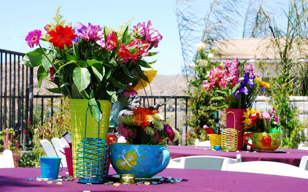 red and pink flowers in blue ceramic vase