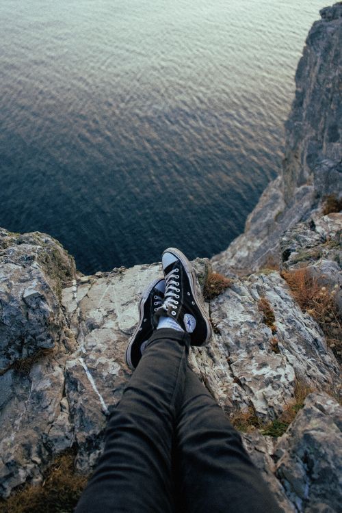 Person in Schwarzen Hosen Und Schwarz-weißen Nike-Turnschuhen, Die Auf Felsen Sitzen Sitting. Wallpaper in 4000x6000 Resolution