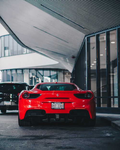 Image red ferrari car parked near building