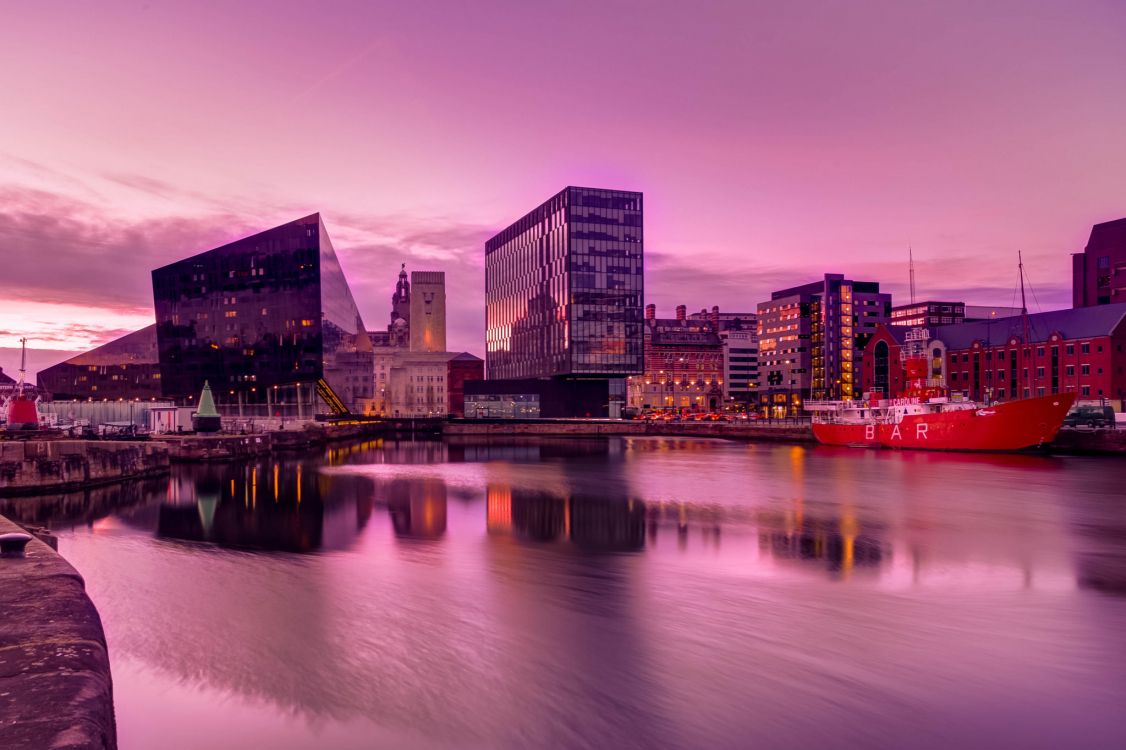 city skyline near body of water during sunset