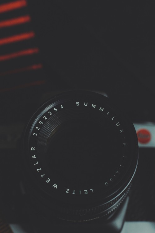 Image black camera lens on red and white striped textile