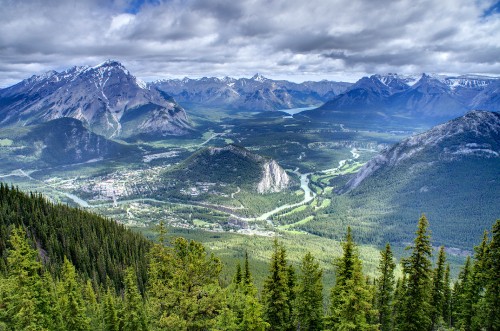 Image green trees and mountains under white clouds and blue sky during daytime