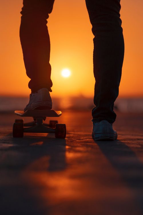 Person in Black Pants and White Sneakers Standing on Brown Wooden Skateboard. Wallpaper in 4000x6000 Resolution