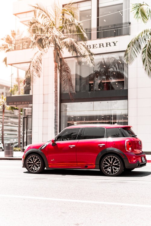 Image red sedan parked near building during daytime