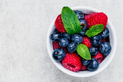 Image raspberry and blueberry in white ceramic bowl