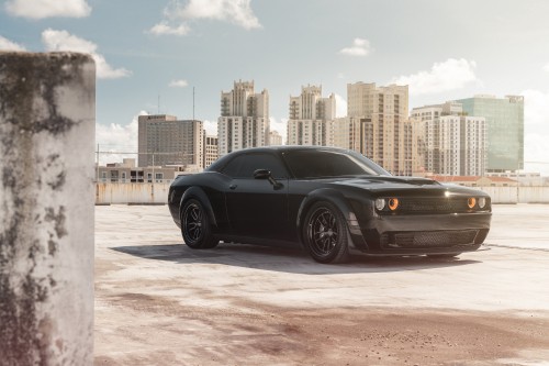 Image black coupe parked on gray concrete pavement during daytime