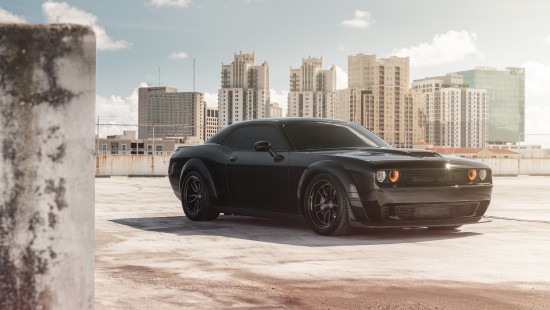 Image black coupe parked on gray concrete pavement during daytime