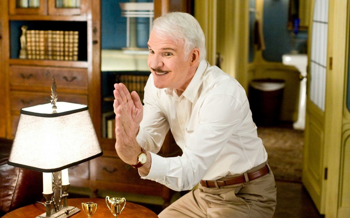 man in white dress shirt and brown pants sitting on chair