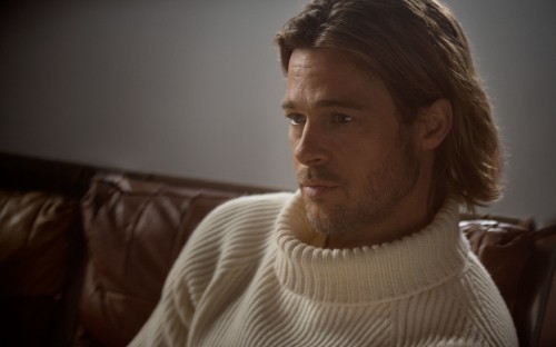 Image man in white knit sweater sitting on brown leather couch