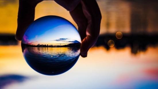 Image person holding blue ball reflecting the sun
