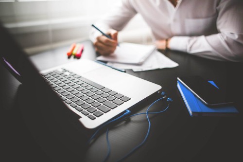 Image person in white dress shirt using macbook pro