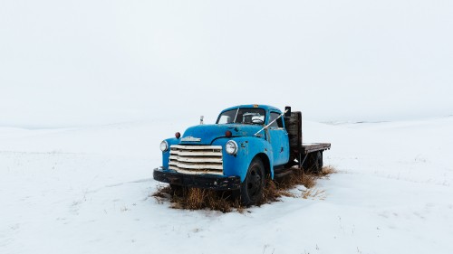 Image blue truck on snow covered ground during daytime