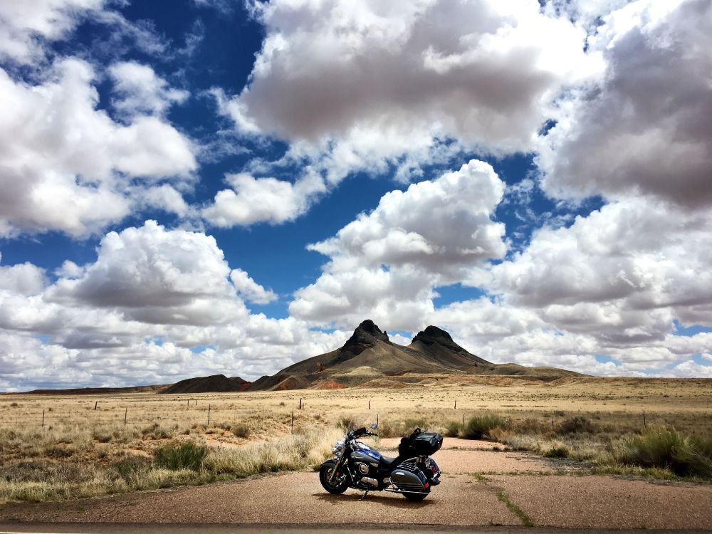 Motocicleta Negra en Campo Marrón Bajo Nubes Blancas y Cielo Azul Durante el Día. Wallpaper in 4032x3024 Resolution