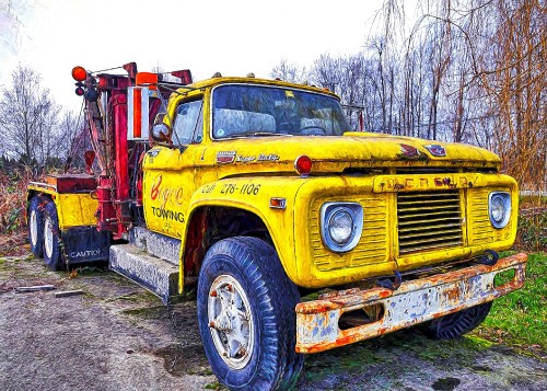 Image yellow and red truck near bare trees during daytime