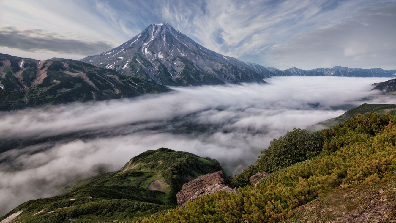 green and black mountain under white clouds during daytime