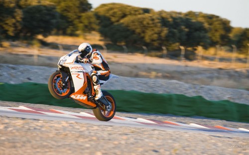 Image man riding orange dirt bike on road during daytime