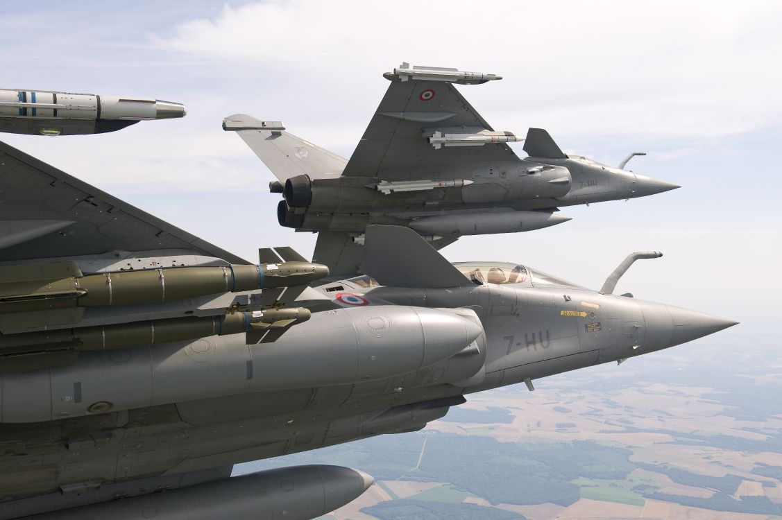 gray fighter jet flying over blue sky during daytime