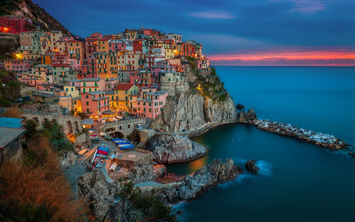 houses on cliff near body of water during daytime