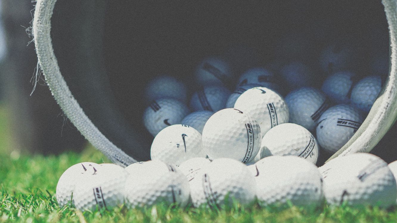 white golf balls in black container