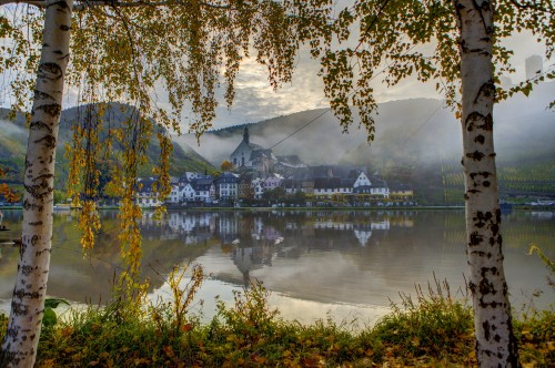 Image body of water near trees and building during daytime