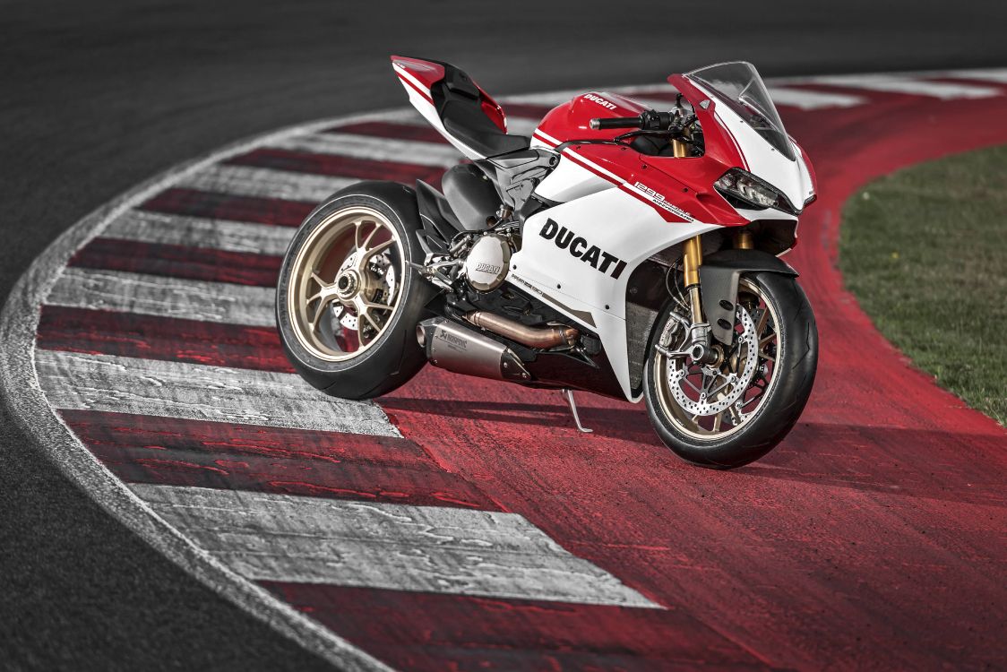 red and white sports bike on track field
