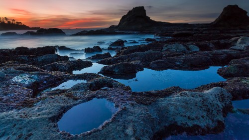 Image rocky shore under cloudy sky during daytime