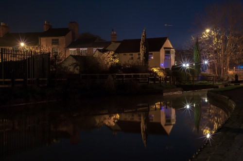 Image brown and white concrete house near body of water during night time