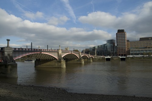 Image white bridge over water near city buildings during daytime