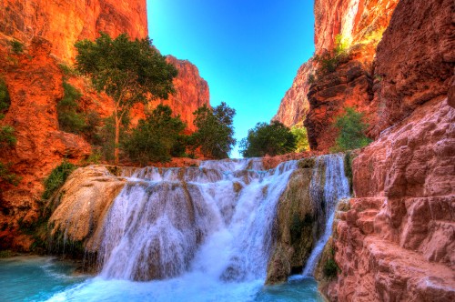 Image waterfalls between brown rocky mountain under blue sky during daytime