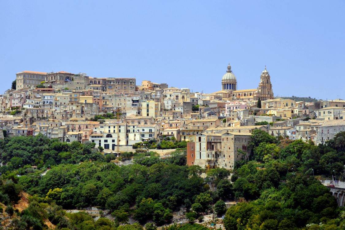 brown and white concrete buildings on mountain