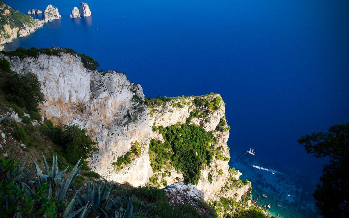 white and green rock formation near blue sea during daytime