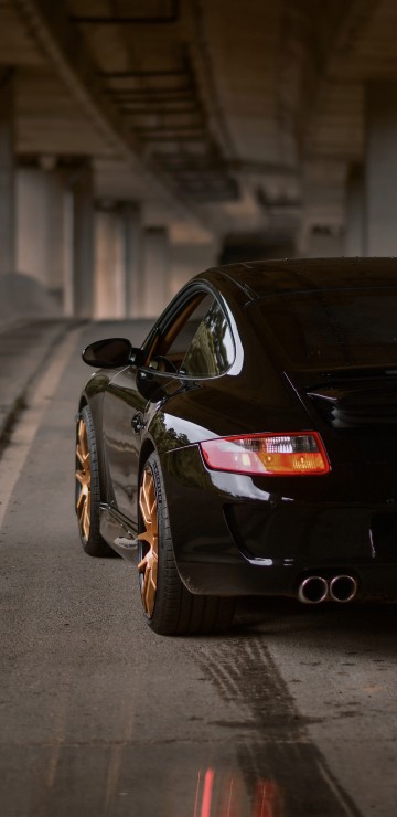 Image black porsche 911 parked on sidewalk during daytime