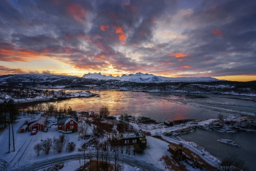 Image snow covered field near body of water under cloudy sky during daytime