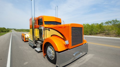 Image orange truck on gray asphalt road during daytime