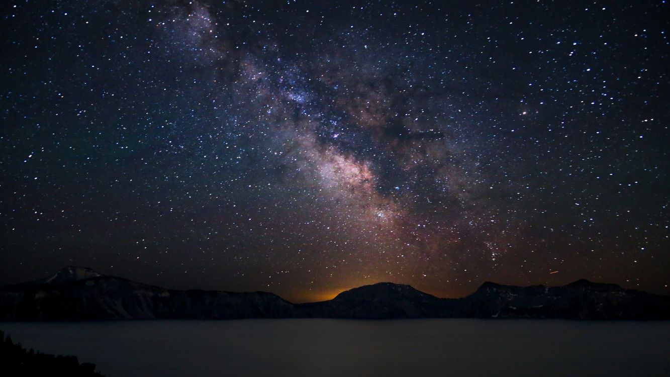 silhouette of mountain under starry night