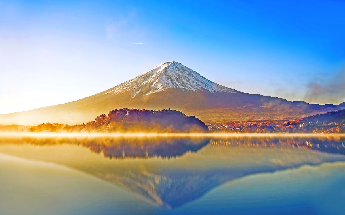 lake near mountain under blue sky during daytime