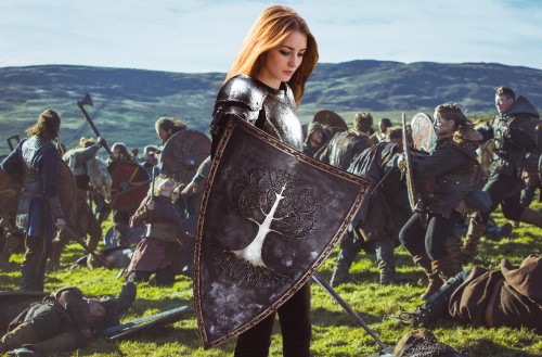 Image woman in black leather jacket holding black shield