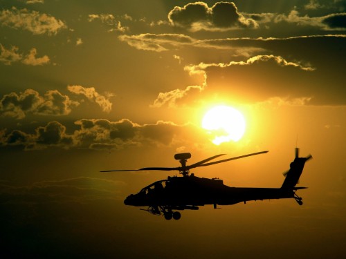 Image silhouette of man riding helicopter under cloudy sky during sunset