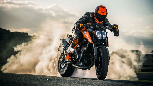 Image man in black and orange motorcycle suit riding black sports bike